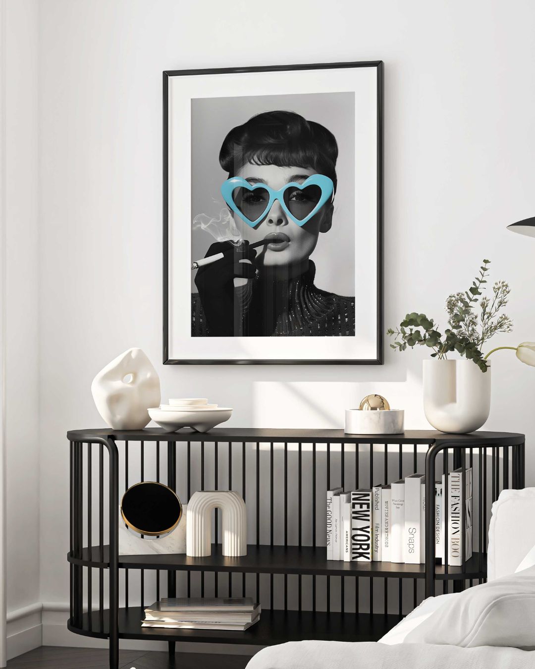 affiche d'art avec audrey hepburn fumant une cigarette et portant des lunettes en forme de coeur mis en situation dans un cadre noir au milieu d'un salon