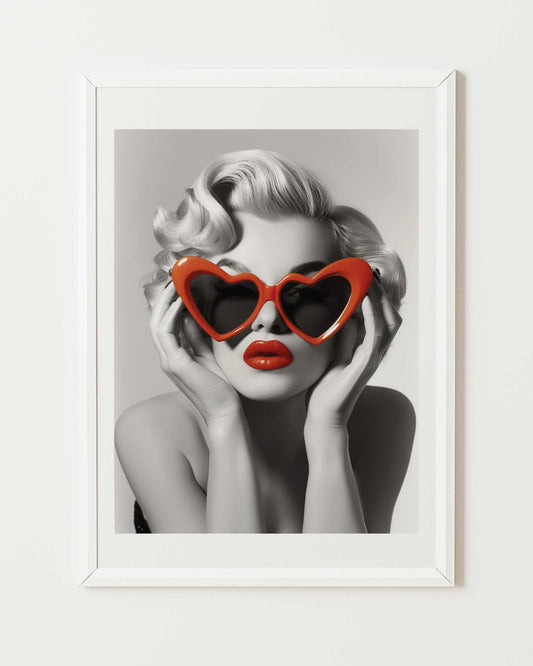 affiche d'art de Marilyn Monroe en noir et blanc portant des lunettes plastique rouge en forme de coeur, affiche mise en situation dans un cadre blanc